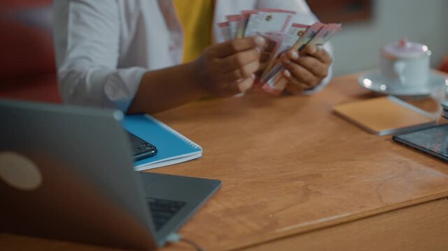 Closeup of Businessman hands counting 100,000 rupiah cash banknote.