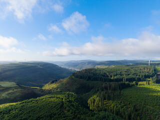 Fototapeta premium Aerial View of South Wales Valleys with Dense Forest Covered Mountains with Blaenrhondda Village in the Distance. 
