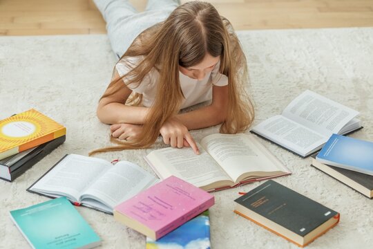 Middle School Student Studying with Many Books at Home