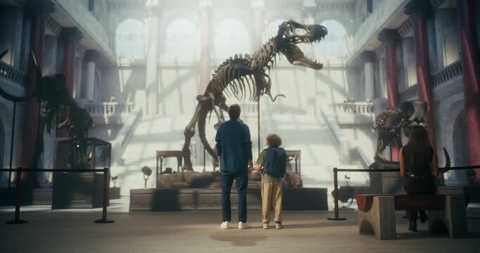 At Grand Natural History Museum Father and Young Son Hold Hands, Looking up at a Towering T-rex Dinosaur Skeleton, Family Togetherness While Learning and Exploring Prehistoric Wonders Together.