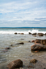 Fototapeta premium Rocky east coast of denmark with crashing waves. Vertical natur background.