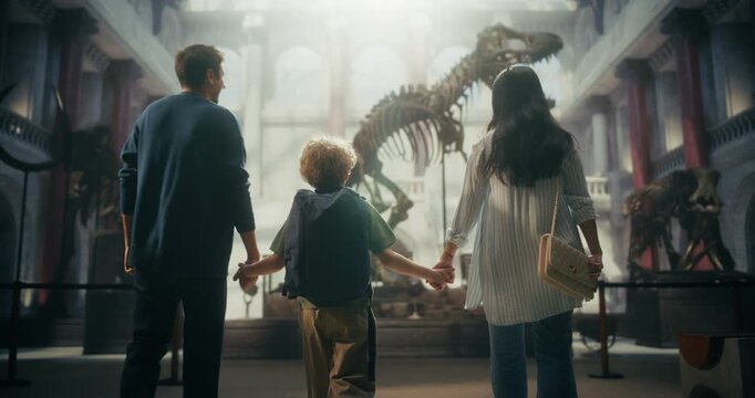Natural History Museum Family Visit: Mother, Father and Son Walk Together Towards Dinosaur Skeleton Exhibition, Enjoying Time and Learning About Ancient Fossils. Having Fun as a Family. Slow Motion