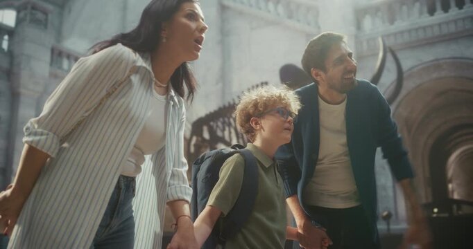 Natural History Museum Visit: Mother, Father and Child Walk Together Through, Looking at Animal Fossils and Smiling While Learning About Prehistoric Creatures. Side Arc View Portrait