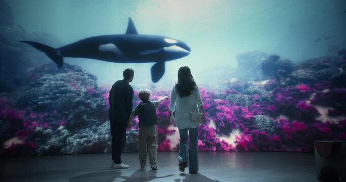 Oceanarium Marine Mammal Park Invites a Curious Family to Explore an Killer Whale Exhibit, Mother, Father and Child Pointing With Excitement While Discovering Underwater Ocean Life 