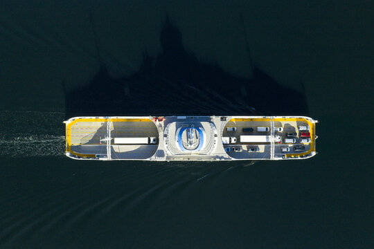 Aerial view of a ferry carrying vehicles across dark water in Afarnes, More og Romsdal, Norway.