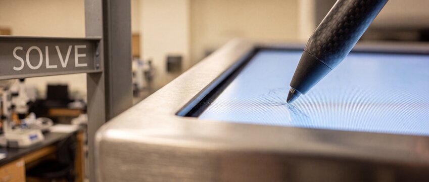 Stylus pen touching touchscreen display with solve sign in modern science research laboratory environment for technology testing and innovative digital engineering development solutions concept focus.