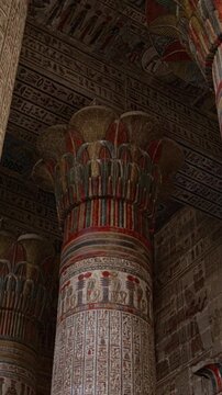 The temple of Esna, dedicated to the god Khnum. Egypt. Esna temple hypostyle hall with massive painted columns and colorful hieroglyphic reliefs on ceiling in Egypt, ancient Roman-era architecture wit