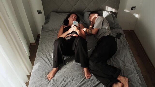 Passive aggression in relationship as woman ignores partner while focused on smartphone, emotional withdrawal, silent treatment and lack of communication in modern couple at home