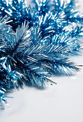 Fototapeta premium Blue metallic Christmas tinsel close-up on white background