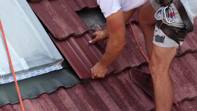 Roof renovation showing replacement of damaged roof tiles, maintenance work on a residential building with workers repairing roofing structure and restoring surface during outdoor daylight.