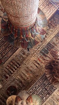 The temple of Esna, dedicated to the god Khnum. Egypt. Esna temple hypostyle hall with massive painted columns and colorful hieroglyphic reliefs on ceiling in Egypt, ancient Roman-era architecture wit