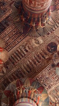 The temple of Esna, dedicated to the god Khnum. Egypt. Esna temple hypostyle hall with massive painted columns and colorful hieroglyphic reliefs on ceiling in Egypt, ancient Roman-era architecture wit