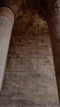 The temple of Esna, dedicated to the god Khnum. Egypt. Esna temple hypostyle hall with massive painted columns and colorful hieroglyphic reliefs on ceiling in Egypt, ancient Roman-era architecture wit