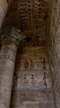 The temple of Esna, dedicated to the god Khnum. Egypt. Esna temple hypostyle hall with massive painted columns and colorful hieroglyphic reliefs on ceiling in Egypt, ancient Roman-era architecture wit