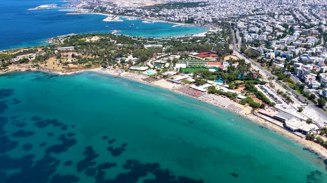 Aerial view of the popular coast and beach of Voula with the skyline of Athens in the background, Greece