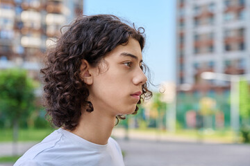 Profile portrait of curly teen boy outdoors © Valerii Honcharuk