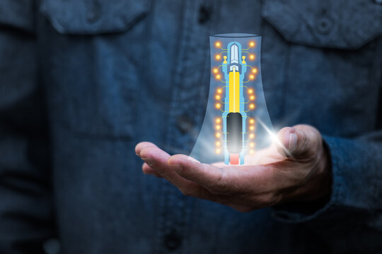Small nuclear power plant icon on man's hand on natural background.Alternative energy for the future transition to a low-carbon electricity system concept.