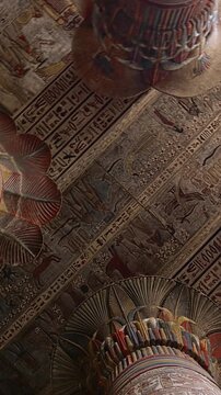 The temple of Esna, dedicated to the god Khnum. Egypt. Esna temple hypostyle hall with massive painted columns and colorful hieroglyphic reliefs on ceiling in Egypt, ancient Roman-era architecture wit