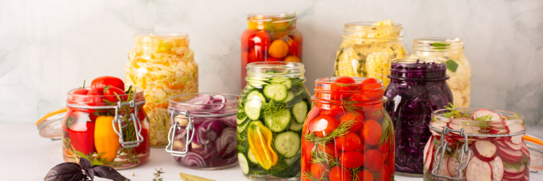 Fresh vegetables like cabbage, tomatoes, cucumbers and radishes, onions, corn, peppers and cauliflower, fermenting naturally to boost health and preserve nutrients, banner