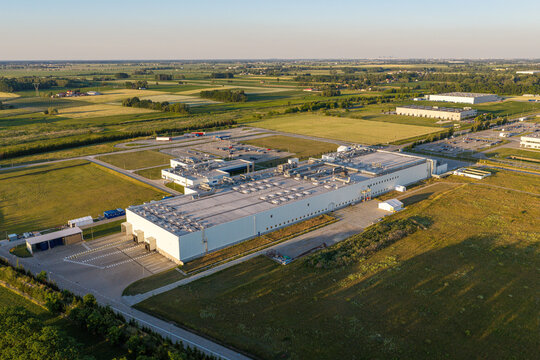 Aerial view of the Mars Polska manufacturing facility in Blonie, featuring large industrial buildings, parking lots, and surrounding green fields in Pass, Masovian Voivodeship, Poland.