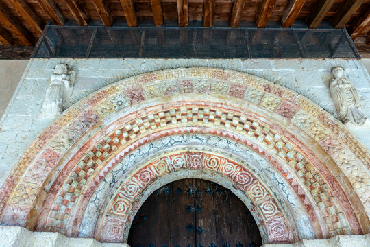 Detail of the 12th-century Romanesque entrance portal featuring polychrome molded archivolts with floral and checkered geometric relief carvings at the Hermitage of Nuestra Se&ntilde;ora de las Vegas. Spain