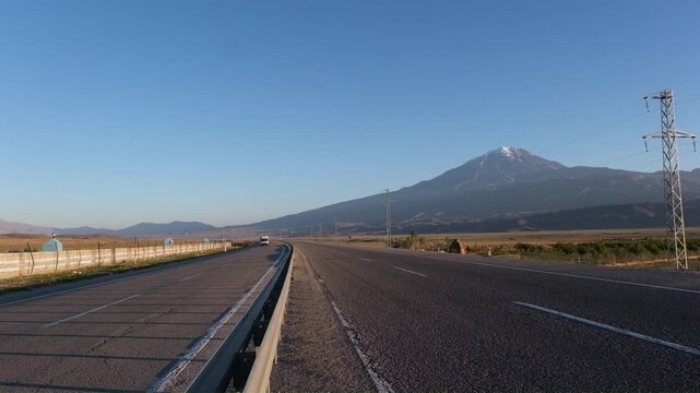Truck drives along the highway past Mount Greater Ararat, view from the Turkish side