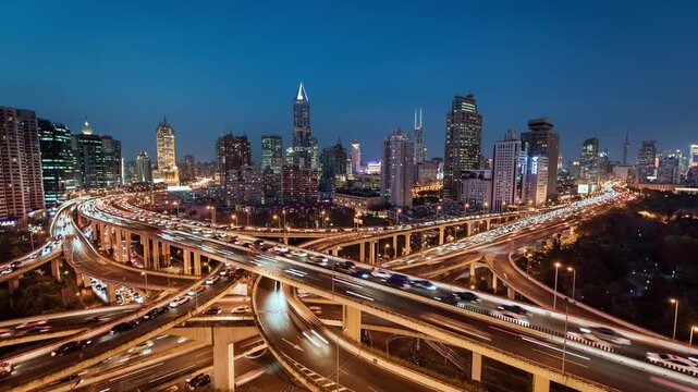 Day to night transition time lapse of busy elevated road intersection with commuters at night, Asia, China, Shanghai	
