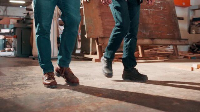 Carpentry, walking and legs of men in workshop for manufacturing, timber business and woodwork. Team, contractor and people in warehouse for wood production, furniture restoration and collaboration