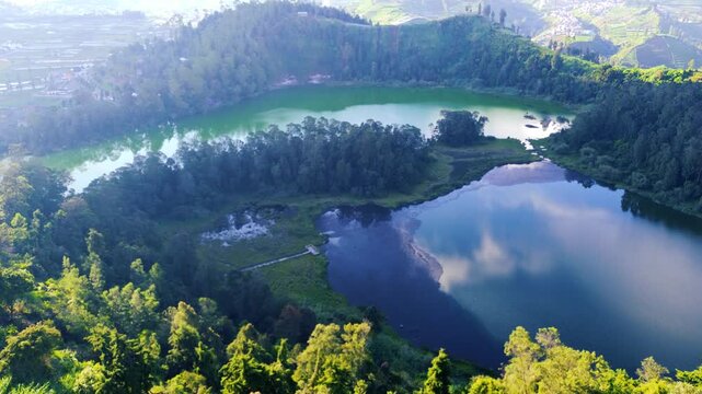 Aerial drone footage of Telaga Warna (Color Lake) on the Dieng Plateau, Central Java, Indonesia, captured during the late afternoon golden hour. 