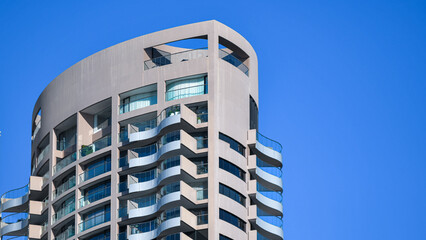 Modern residential tower with curved balconies against blue sky © Structural Light