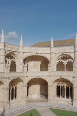 Obraz premium Jerónimos Monastery Cloister Arcade with Spires Against a Clear Blue Sky