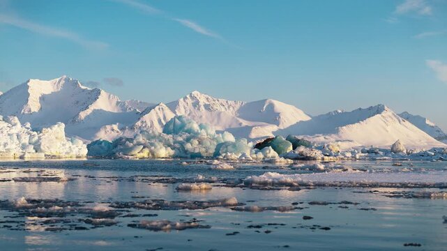 Icebergs floating against majestic snowy mountains in arctic Svalbard