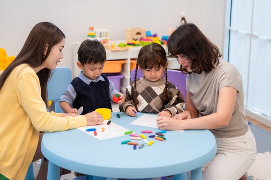 Children and adults engage in a craft activity at a bright learning center during the afternoon hours