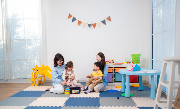 Children play with toys in a room with colorful furniture and a bright atmosphere during a sunny day