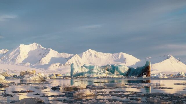 Icebergs floating against majestic snowy mountains in arctic Svalbard