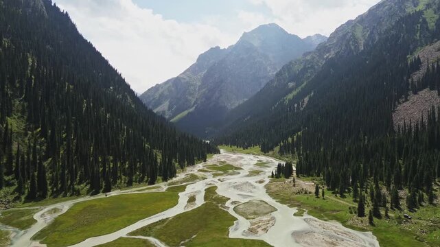 Aerial Wide View of Braided River Flowing Through Lush Green Mountain Valley