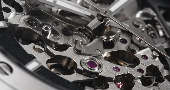 Macro close up of skeleton mechanical watch movement with visible gears and jewel bearings