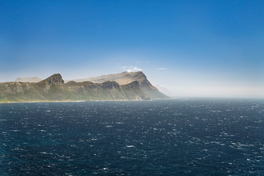 Stormy sea and rugged mountains at Cape Point South Africa