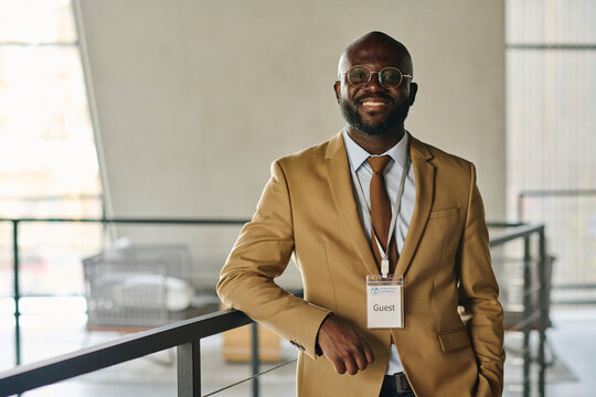 Confident smiling businessman in suit standing at convention center