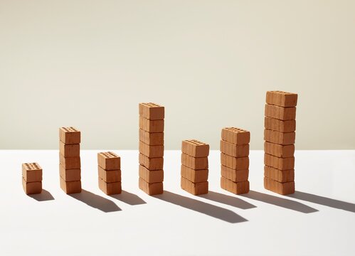 Miniature red bricks stacked as a bar chart showing growth