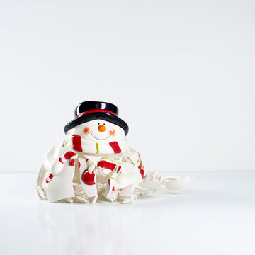 Shattered porcelain snowman on white background