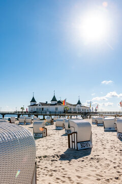 Germany, Mecklenburg-Vorpommern, Ahlbeck, Sun shining over hooded beach chairs with bathhouse in background