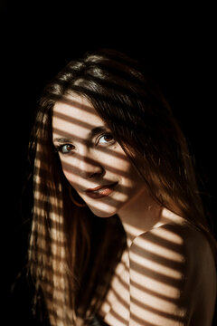 Portrait with dramatic light and shadow pattern from a blind
