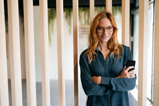 Portrait of confident businesswoman holding cell phone