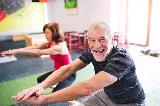 Senior man and woman exercising in gym