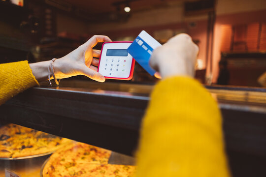 Hands of woman making payment through credit card at cafe