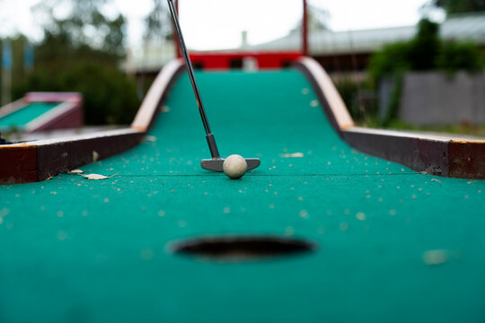 Ball and club playing miniature golf