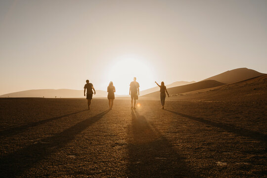 Namibia, Namib desert, Namib-Naukluft National Park, Sossusvlei, friends walking at Dune 45 at sunrise