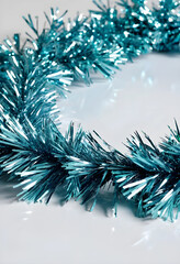 Fototapeta premium Blue metallic tinsel garland on white background