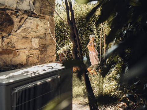 Playing with a ball in a Tuscany backyard near a heat pump